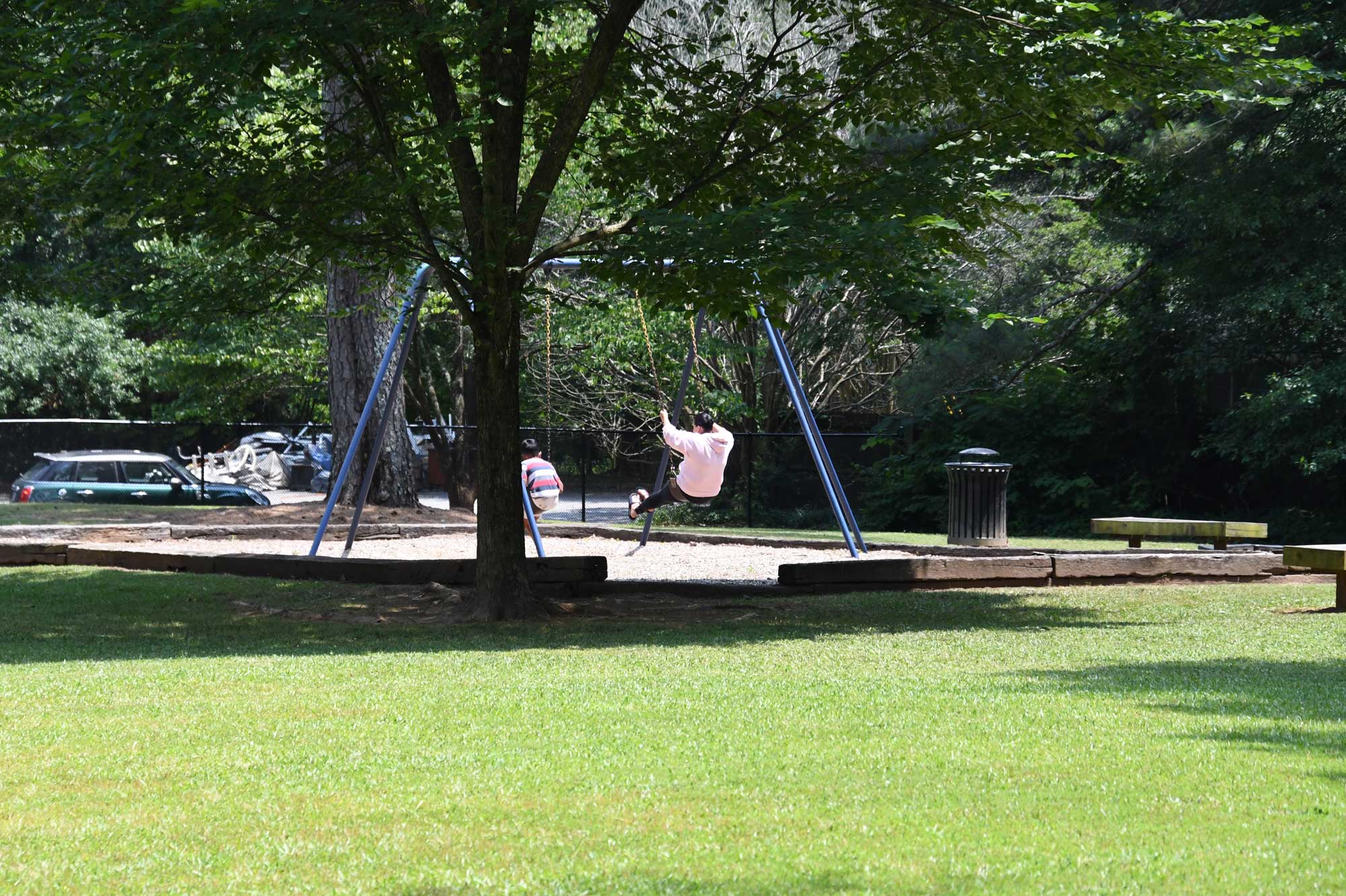 Parent and child enjoying the swings at Montreal Park.