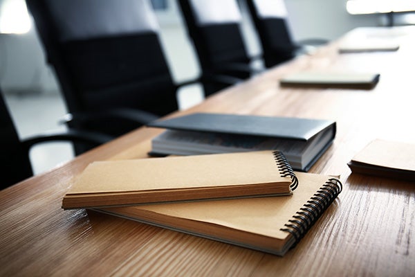 Notebooks on a conference table with chairs