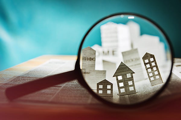 Paper house under a magnifying lens.