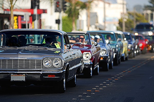 Classic cars driving down a road.