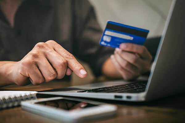 Businessman holding credit card and typing on laptop for online