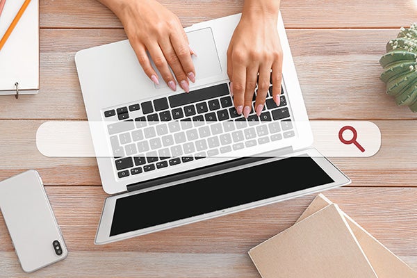 Young woman working on laptop at table. Concept of search