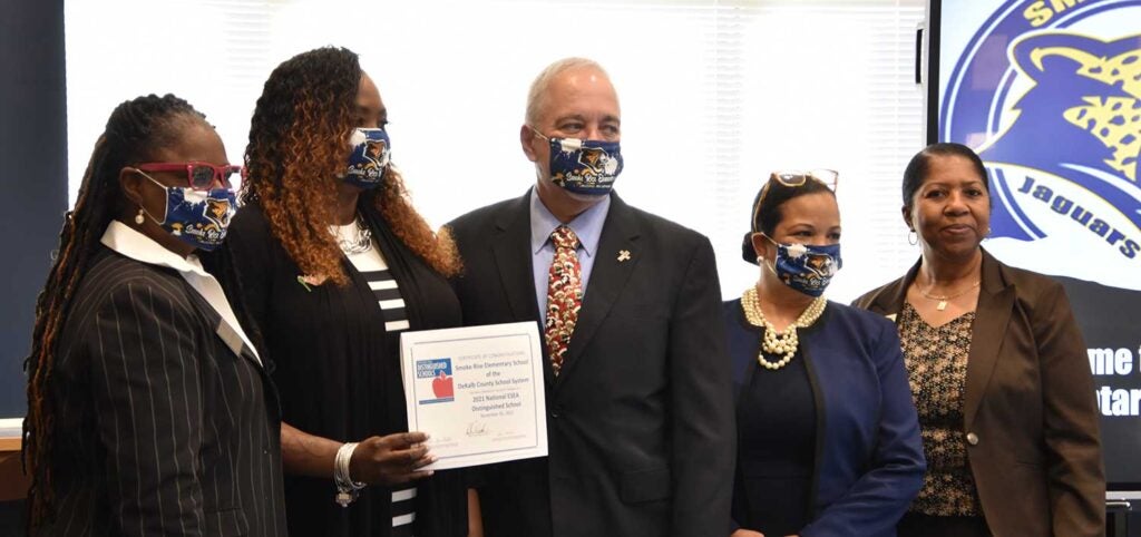 Four women and a man are presented with an award