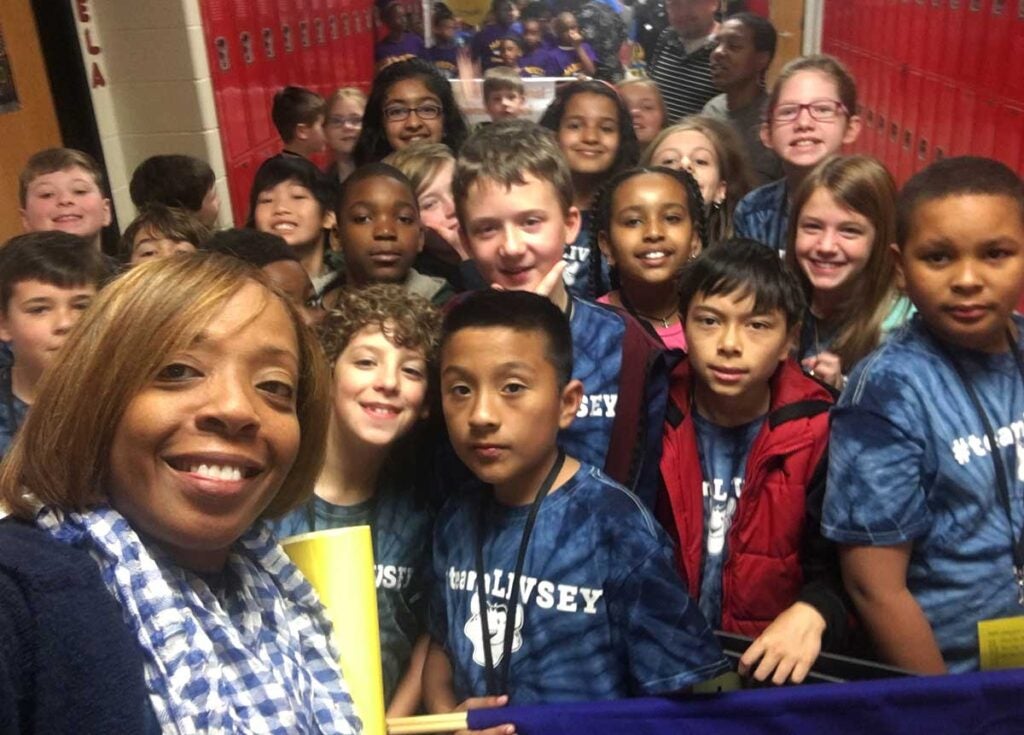 S Kelly taking selfie with many, many children in hallway