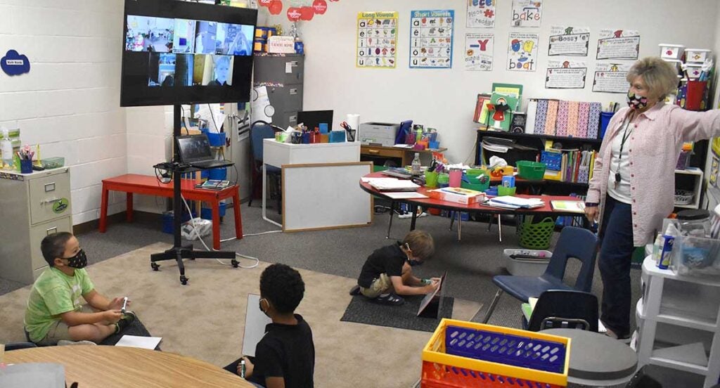 Classroom with young children looking up at teacher