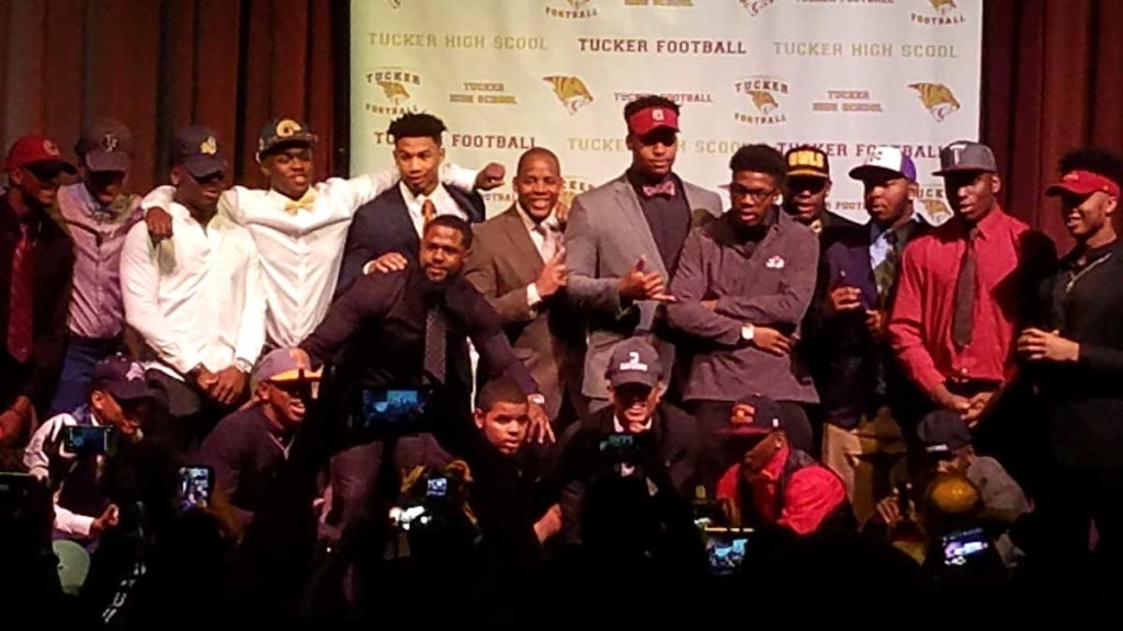 Group of boys stand on a stage before many photographers