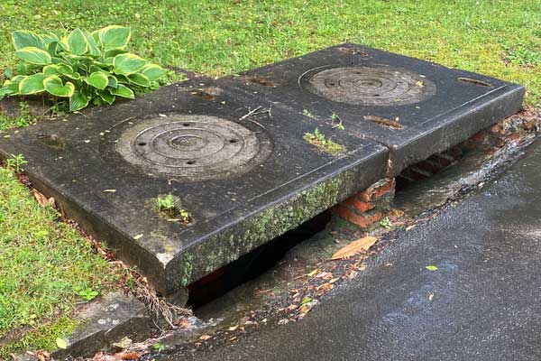 Stormwater catch basin along street curb.