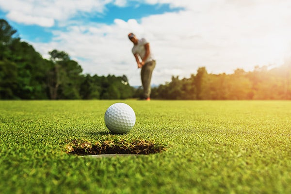 golf ball entering hole