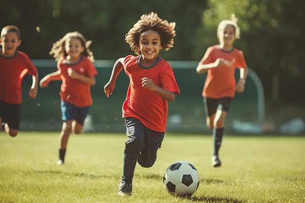 kids on fields chasing soccer ball