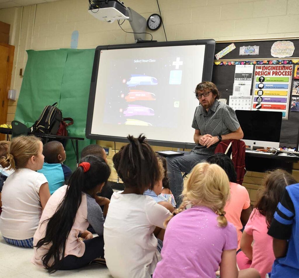 Teacher in the classroom answering questions about STEM