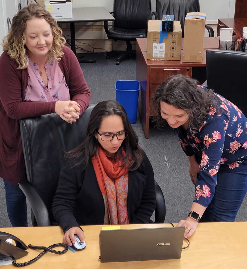 Three woman looking at a computer