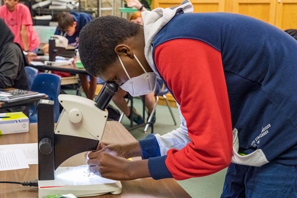 Student looking through a microscope.