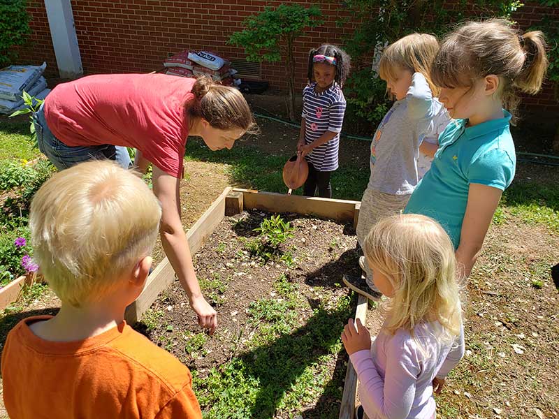 Kids planting seeds in a planter box