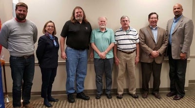 Portrait of a committee against a wall