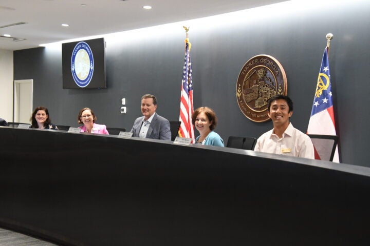 Councilmembers Alexis Weaver, Cara Schroeder, Amy Trocchi, and Vinh Nguyen pose with Mayor Auman behind the dais in the City Council Chambers.