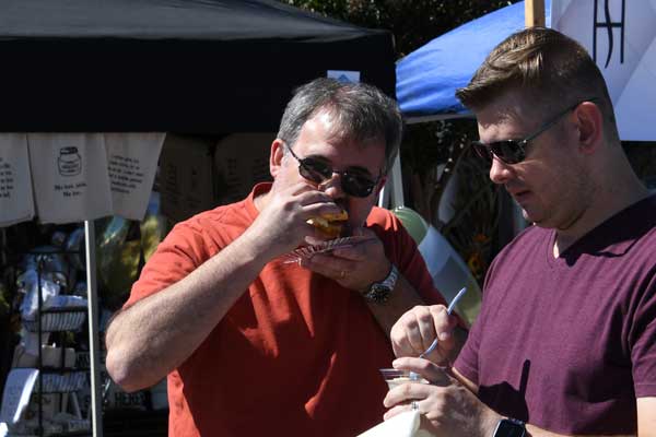 men at Taste of Tucker event eating food