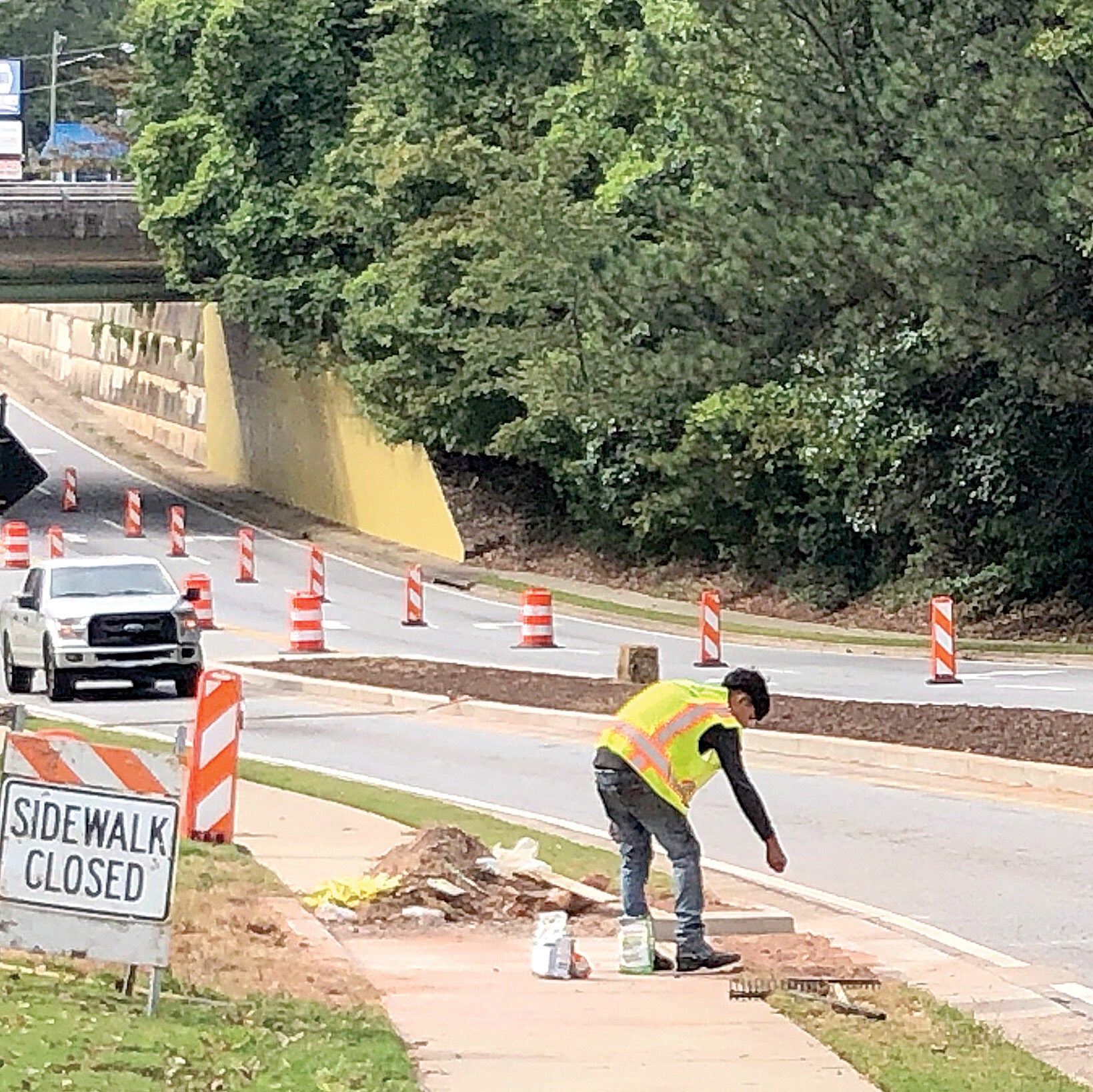 A construction worker works on seeding and strawing on the side of Fellowship Road.