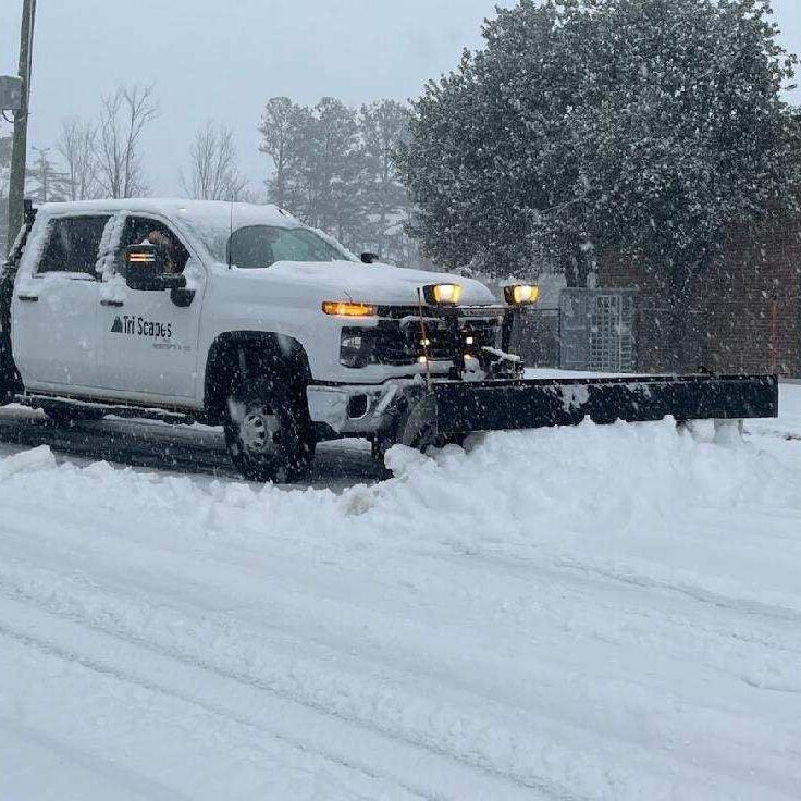 A Tri Scapes truck plows snow on Tucker's roads.